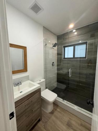 een badkamer met een douche, een toilet en een wastafel bij William Home in Miami