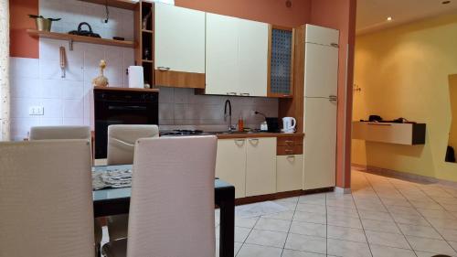 a kitchen with white cabinets and a table and chairs at Casa di Bea in Merate