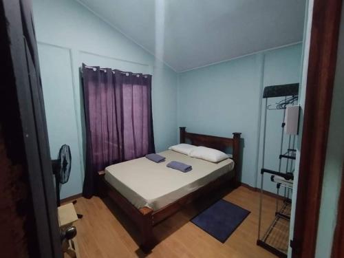 um pequeno quarto com uma cama e um espelho em Green Home em Talamanca