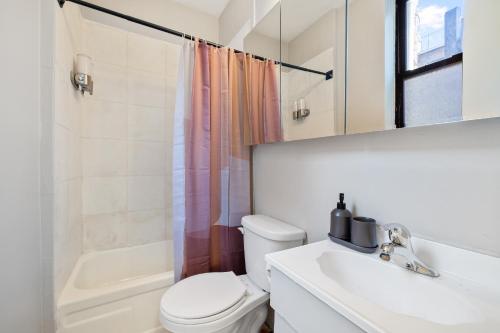 a bathroom with a toilet and a sink and a shower at Inspiring Urban Life, Times square Apartments in New York