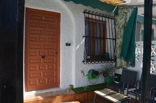 a door of a house with a chair and a window at Casita Amalia in Santa Pola