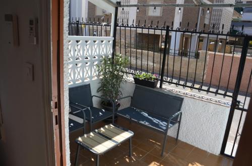 un balcón con 2 bancos azules y una planta en Casita Amalia, en Santa Pola