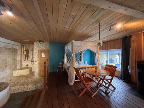 - une chambre avec une table et un lit dans l'établissement Domaine 2 la Tour, Suites & Spas, à Beauzac