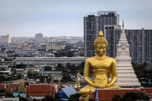 uma grande estátua de ouro em frente a uma cidade em The Homey, 3 min walk to Sky train direct to CBD em Bangkok