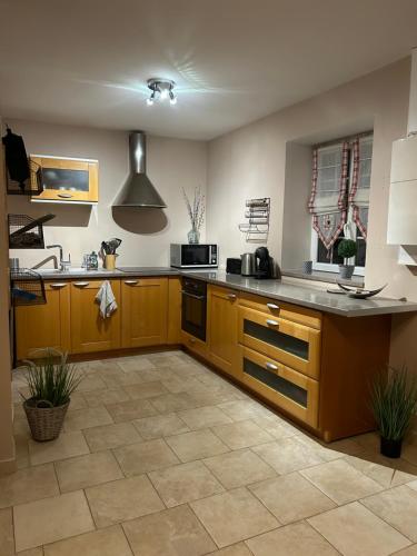 une cuisine avec des armoires en bois et un comptoir dans l'établissement Charmante petite maison en pierre, à Boutigny-sur-Essonnes