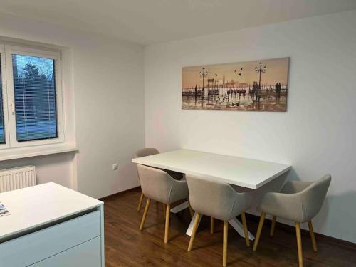 ein Esszimmer mit einem weißen Tisch und Stühlen in der Unterkunft apartmán Alexandra in Prievidza