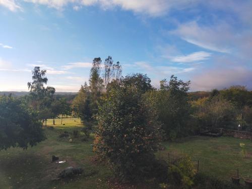 a view of a field with trees and a sky at Chambre d'hôtes Se Sentir Libre Châtaigne in Crozant