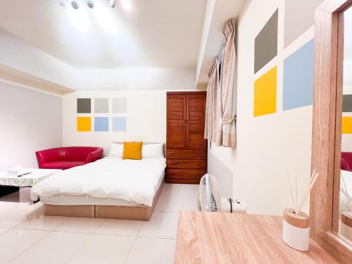 a bedroom with a bed and a red couch at 一中小窩馨 in Taichung