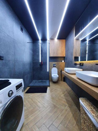 a bathroom with two sinks and a washing machine at Luxury_loft in Kamianets-Podilskyi