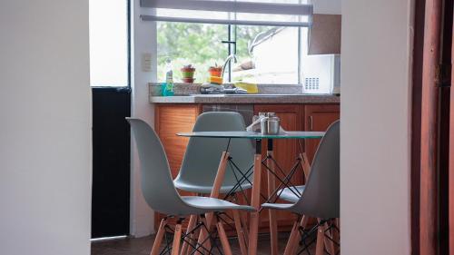 uma cozinha com uma mesa e cadeiras e um lavatório em Casa Roja Residencia 10-51 em Cuenca