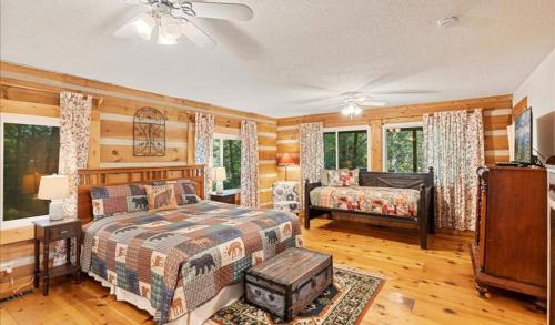 2br Rustic Cabin With Hottub And Foosball Table في غاتلينبرغ: غرفة نوم بسرير واريكة في غرفة