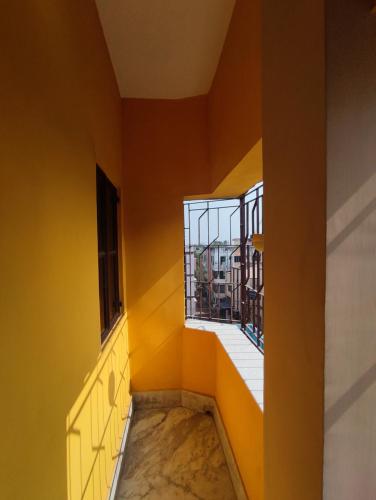 a room with yellow walls and a window at Apartment in Kolkata (Joka-Diamond Park) in Kolkata