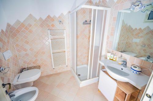 a bathroom with a toilet and a sink and a shower at Aldo Bed & Beauty country house in Arzachena