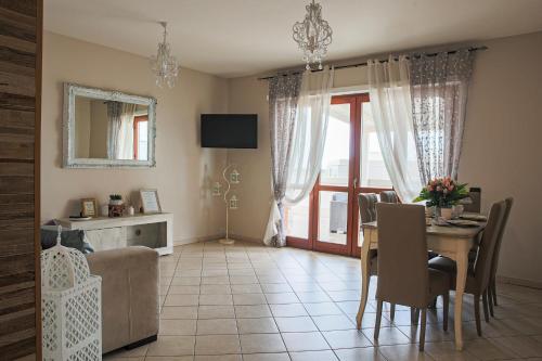 a living room with a table and a dining room at Giramondo Guest house in Fiumicino