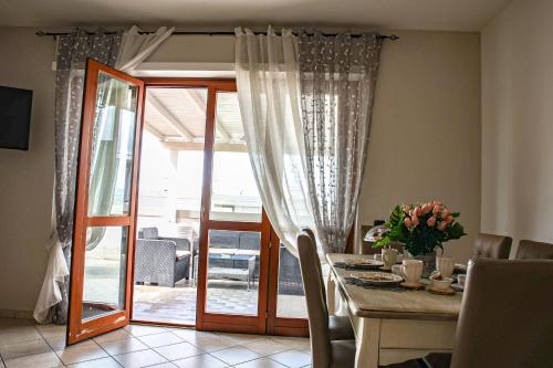 uma sala de jantar com uma mesa e uma porta de vidro em Giramondo Guest house em Fiumicino