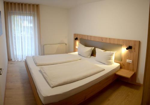 a bedroom with a large bed with white sheets and pillows at Gasthof zur Traube in Bühl