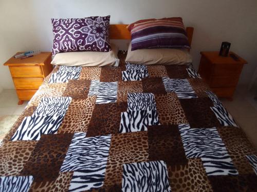 Una cama con edredón en una habitación en Los Tatas, en Manantiales