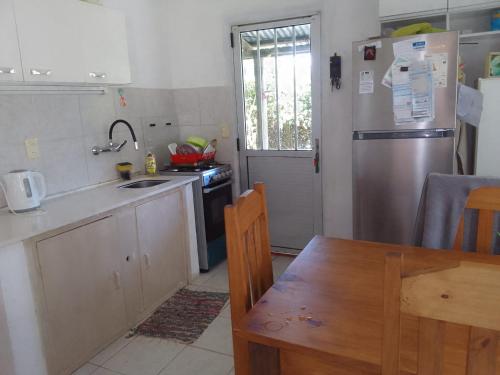 uma cozinha com um frigorífico de aço inoxidável e uma mesa em Los Tatas em Manantiales