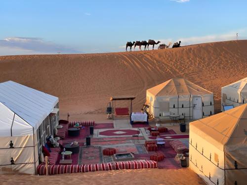 a group of tents in the middle of a desert at Exceptional Luxury Camp in Merzouga
