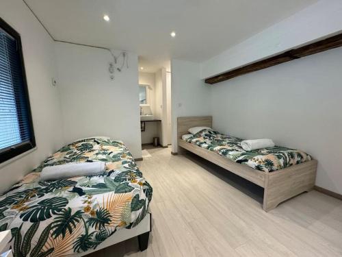 1 dormitorio con 2 camas en una habitación en Moderne corps de ferme - Piscine, en Grésy-sur-Aix