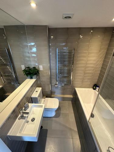 a bathroom with two sinks and a toilet and a tub at Modern Flat in Leigh Broadway in Leigh-on-Sea