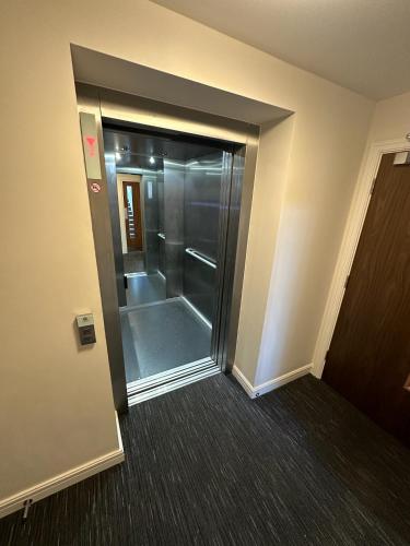 an elevator in a building with a glass door at Modern Flat in Leigh Broadway in Leigh-on-Sea