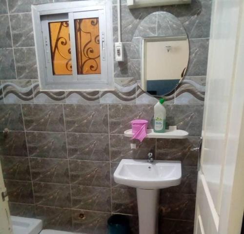 a bathroom with a sink and a mirror at Résidence Sainte Honorine in Yaoundé