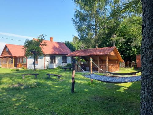 una hamaca en un patio junto a una casa en Leśny domek, en Białowieża
