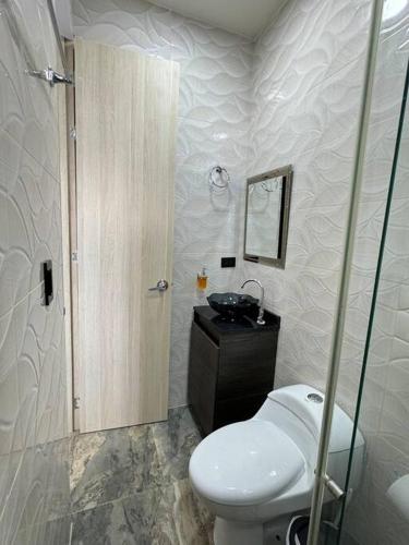 a bathroom with a toilet and a sink at Villa Bella Verde in Acacías