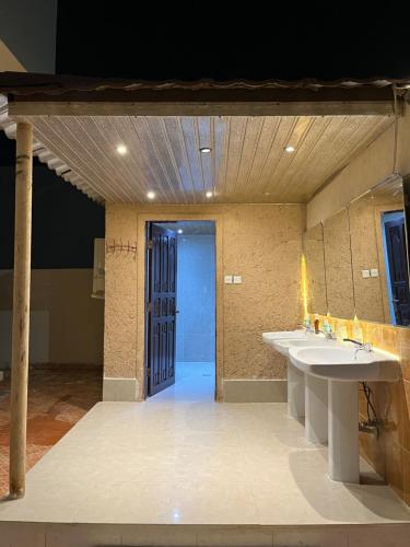 uma casa de banho com dois lavatórios e dois espelhos em شاليه فرحتي em Al Madinah