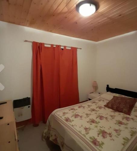 Casa con quincho p 25 p y pileta h-8 per en Potrero de los Funes في سان لويس: غرفة نوم بسرير وستارة حمراء