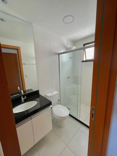 uma casa de banho com um WC, um lavatório e um chuveiro em Apartamento em Praia Grande em Arraial do Cabo