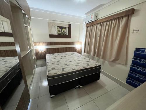 a small room with a bed and a window at Lacqua Diroma Loc Caldas in Caldas Novas