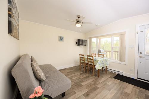 a living room with a couch and a table at Fiddler's Green Country Cottages in Brackley Beach