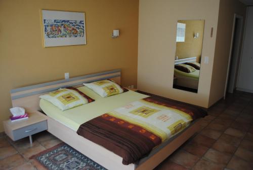 Schlafzimmer mit einem Bett und einem Spiegel in der Unterkunft Motel - Hôtel La Poularde in Romont