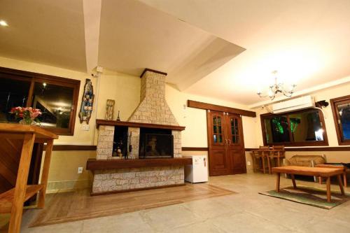 a living room with a brick fireplace in a room at Pousada Paris Hostelli in Penedo