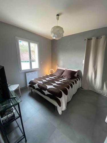 een slaapkamer met een bed en een raam bij Villa à 10 minutes de Nîmes in Marguerittes