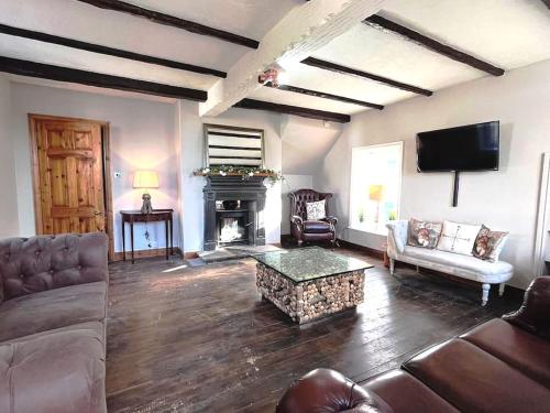 a living room with a couch and a fireplace at Peaceful Countryside Retreat near Beach/Lakes in Distington