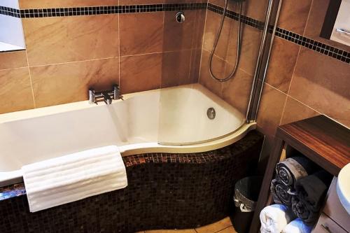 a bath tub in a bathroom with a shower at Peaceful Countryside Retreat near Beach/Lakes in Distington