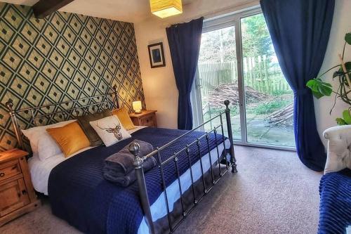 um quarto com uma cama e uma grande janela em Peaceful Countryside Retreat near Beach/Lakes em Distington