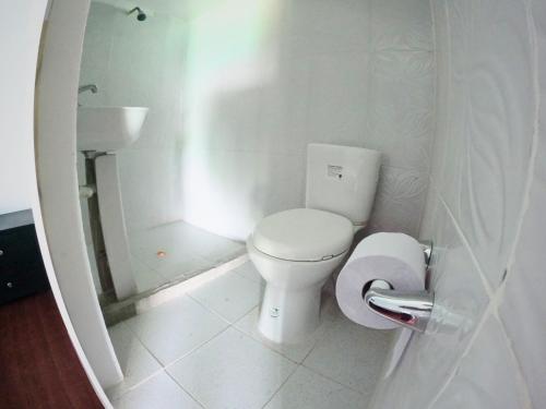 a white bathroom with a toilet and a sink at Posada nativa casa azul in Playa Blanca