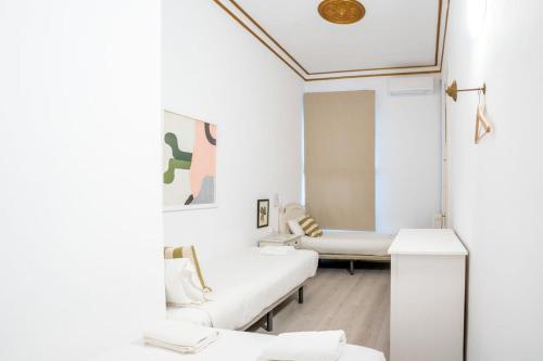 Habitación blanca con muebles blancos y espejo. en Placa Catalunya V Charming and Exquisite 5Bd Apartment with Large Balcony, en Barcelona