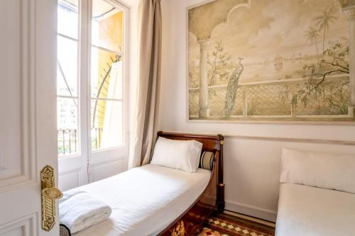 Kleines Zimmer mit einem Bett und einem Fenster in der Unterkunft Placa Catalunya V Charming and Exquisite 5Bd Apartment with Large Balcony in Barcelona