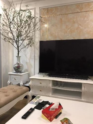 a living room with a flat screen tv and a table at S1-05A11A-Sapphire Hạ Long in Ha Long