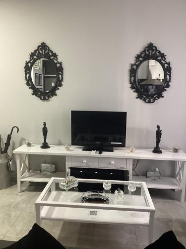 a living room with a white table with two mirrors at María y Juan Apartamento con Garaje in Sanlúcar de Barrameda