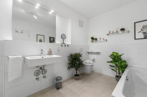 a white bathroom with a sink and a toilet at Tolles Design & luxuriös, super komfortabel, 14 min Köln Zentrum (Bahn), Köln-Messe, Düsseldorf, Phantasialand in Hürth