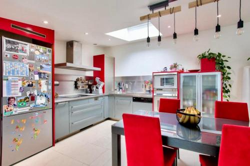 La cuisine est équipée de placards rouges et d'un grand réfrigérateur. dans l'établissement Amazing house between Bastille and Gare de Lyon, à Paris