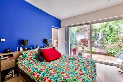 une chambre avec un grand lit avec un oreiller rouge dans l'établissement Amazing house between Bastille and Gare de Lyon, à Paris