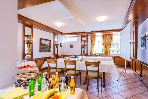 a dining room with white tables and chairs at Boutique- und Businesshotel Herrenküferei in Markgröningen