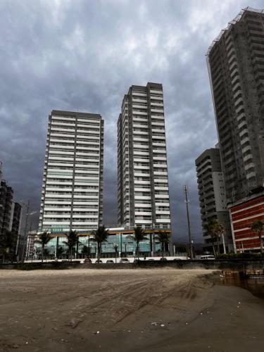 trzy wysokie budynki w mieście z polną drogą w obiekcie Edifício Dubai temporada na Praia w mieście Solemar